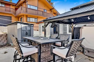 a patio with a table and chairs and a grill at Highland Hideaway at Big Bear | Cozy Cabin w/ Private Hot Tub in Big Bear Lake