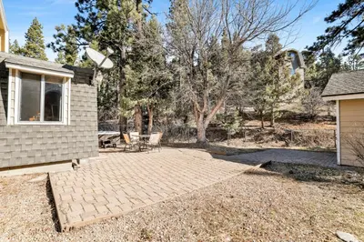 a backyard with a patio and a house at The Cave at Big Bear Lake - Adorable Mountain Retreat w/ Hot Tub in Big Bear Lake