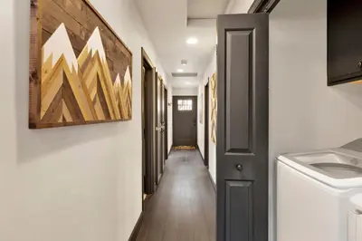 a hallway leading to a laundry room with a washer and dryer at Cielos Nest Cabin | Close to Village and Lake with Hot Tub in Big Bear Lake