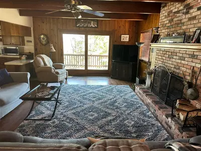 a living room with a fireplace and a brick wall at Le Studio de Sud in Lake Arrowhead