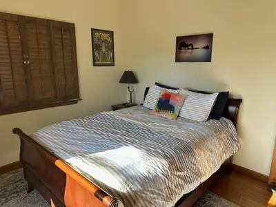 a bedroom with a bed with a striped comforter at Le Studio de Sud in Lake Arrowhead