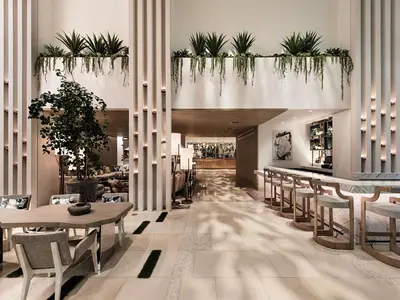 a lobby with a table and chairs and plants at Dream Hollywood, by Hyatt in Los Angeles
