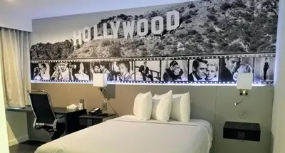 a hotel room with a bed and a sign on the wall at Glen Capri Inn and Suites - Burbank Universal in Glendale
