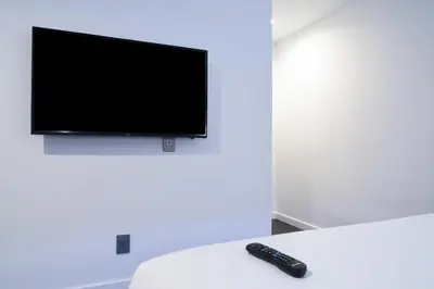a remote control sitting on a table in front of a tv at Glen Capri Inn and Suites - Burbank Universal in Glendale