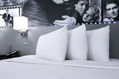 a bedroom with a bed with pillows and posters at Glen Capri Inn and Suites - Burbank Universal in Glendale