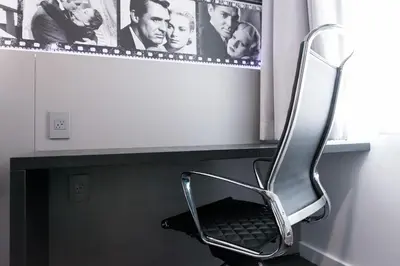 a chair sitting under a window in a room at Glen Capri Inn and Suites - Burbank Universal in Glendale