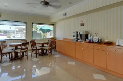 a kitchen with a table and some chairs and a table and a tablektop at Vagabond Inn Hacienda Heights in Hacienda Heights