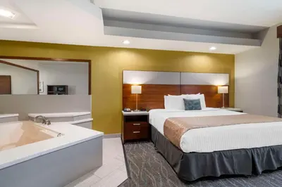 a hotel room with a bed and a bath tub at Best Western Plus Gardena-Los Angeles Inn & Suites in Gardena
