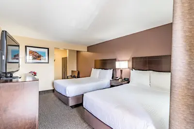 a hotel room with two beds and a sink at Grand Legacy At The Park in Anaheim