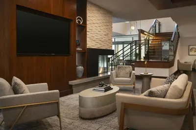 a living room with a flat screen tv and chairs at Residence Inn by Marriott Los Angeles Pasadena/Old Town in Pasadena