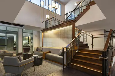 a living room with a staircase with a couch and a chair at Residence Inn by Marriott Los Angeles Pasadena/Old Town in Pasadena