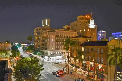 a city street at night with cars and buildings at Hotel Royal in Long Beach