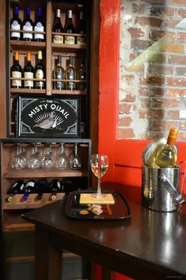 a table with a glass of wine and wine bottles at Hotel Royal in Long Beach
