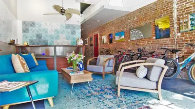 a living room with a blue couch and bikes on a brick wall at Hotel Royal in Long Beach