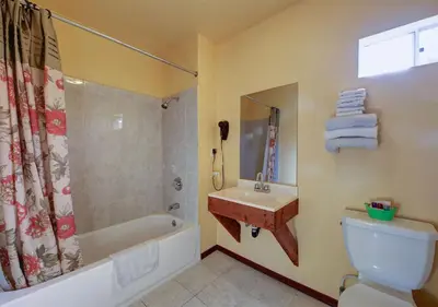 a bathroom with a tub and a toilet and a sink at Welcome Inn in Inglewood