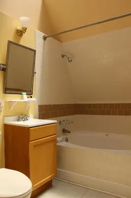 a bathroom with a tub and a toilet and a sink at Glen Tavern Inn in Santa Paula