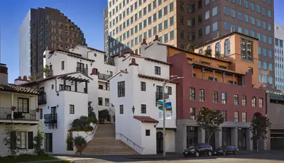 a white building in the middle of a city at Plaza la Reina in Los Angeles