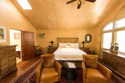 a bedroom with a bed and two chairs at The Emerald Iguana Inn in Ojai