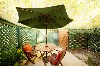 a table and chairs with an umbrella on a patio at The Emerald Iguana Inn in Ojai