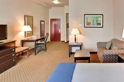 a hotel room with a bed and a couch and a desk at Holiday Inn Express Delano Highway 99 by IHG in Delano