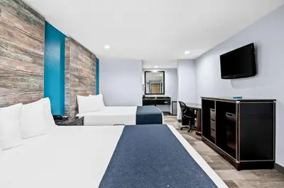 a hotel room with two beds and a tv at SureStay Hotel by Best Western Buena Park Anaheim in Buena Park