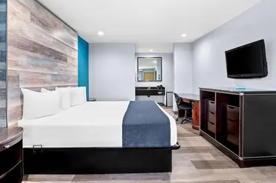 a bedroom with a bed and a desk and a television at SureStay Hotel by Best Western Buena Park Anaheim in Buena Park