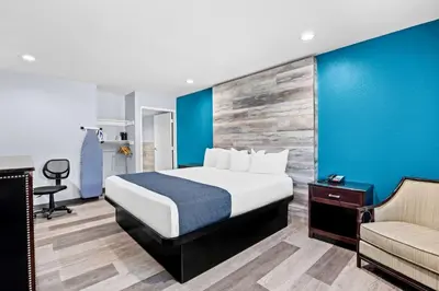 a hotel room with a bed and a couch at SureStay Hotel by Best Western Buena Park Anaheim in Buena Park