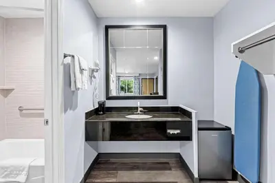a bathroom with a sink and a mirror at SureStay Hotel by Best Western Buena Park Anaheim in Buena Park