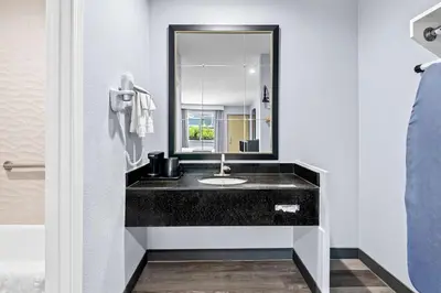 a bathroom with a black sink and a mirror at SureStay Hotel by Best Western Buena Park Anaheim in Buena Park