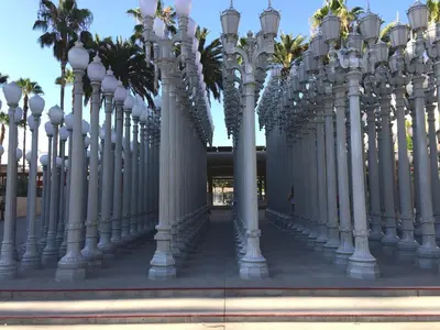 a row of white street lights in front of a building at American Inn Downey in Downey