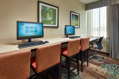 a room with two computers on a desk with chairs at Staybridge Suites Anaheim At The Park by IHG in Anaheim