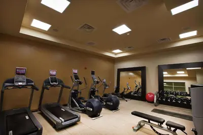 a gym with treadmills and ellipticals in a room at Embassy Suites Palmdale in Palmdale