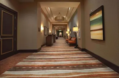 a hallway of a hotel with a rug on the floor at Embassy Suites Palmdale in Palmdale