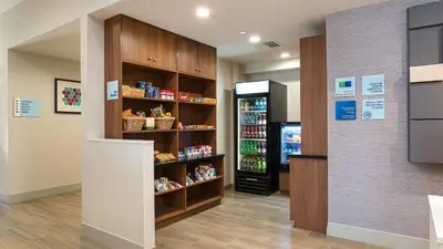 a grocery store aisle with a refrigerator and shelves of food at Holiday Inn Express Fullerton-Anaheim by IHG in Fullerton