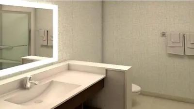 a bathroom with a sink and a mirror and a toilet at Holiday Inn Express Fullerton-Anaheim by IHG in Fullerton