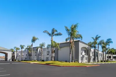 a building with palm trees in front of it at Hourglass Hotel, Trademark Collection by Wyndham in Bakersfield