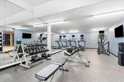 a gym with several treadmills and exercise machines at Hourglass Hotel, Trademark Collection by Wyndham in Bakersfield