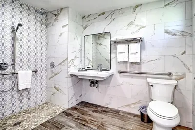 a bathroom with a toilet and a sink and a mirror at White Caps Motel in Ventura