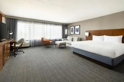 a large hotel room with a bed and a couch at Courtyard by Marriott Los Angeles Woodland Hills in Woodland Hills