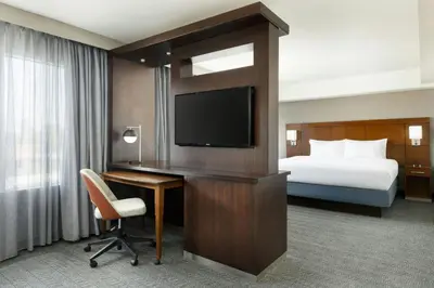 a hotel room with a bed and a desk with a television at Courtyard by Marriott Los Angeles Woodland Hills in Woodland Hills