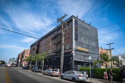 a building on a city street with cars parked on the street at H by H Hospitality in Los Angeles