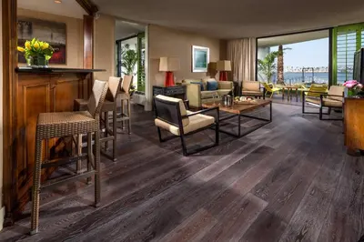 a living room with hardwood floors and a living room with furniture at Hotel Maya in Long Beach