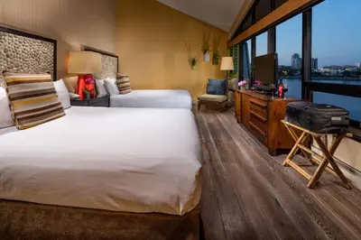 a hotel room with two beds and a television at Hotel Maya in Long Beach