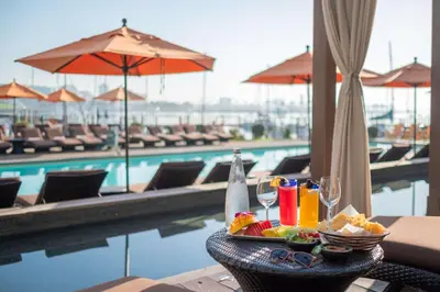 a table with a tray of food and drinks next to a pool at Hotel Maya in Long Beach