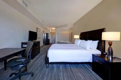 a hotel room with a bed and a desk and a computer at Hilton Garden Inn San Bernardino in San Bernardino