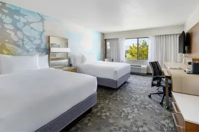 a hotel room with two beds and a desk at Courtyard by Marriott Palmdale in Palmdale