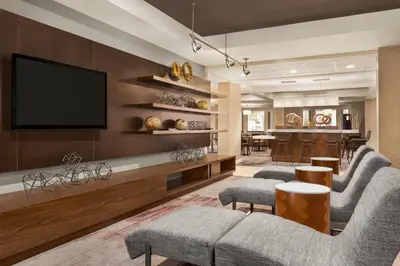 a living room with a flat screen tv on a wall at Courtyard by Marriott Palmdale in Palmdale