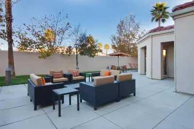 a patio with couches and tables and trees at Courtyard by Marriott Palmdale in Palmdale
