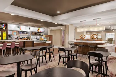 a restaurant with tables and chairs and a bar at Courtyard by Marriott Palmdale in Palmdale