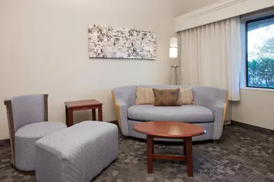 a living room with a couch and a chair and a table at Courtyard by Marriott Palmdale in Palmdale